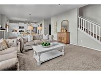 Cozy living room features a tufted couch, white coffee table, and seamless access to a modern white kitchen at 20727 Park Hollow Dr, Parker, CO 80138