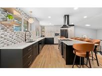 Modern kitchen with sleek countertops, stainless steel appliances, a central island, and hardwood floors at 14533 W 3Rd Ave, Golden, CO 80401