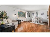 Bright dining area features hardwood floors, a large window, and elegant furnishings at 10983 W Exposition Pl, Lakewood, CO 80226
