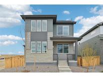 Stylish two-story home with gray siding, stone accents, and a welcoming front porch at 21091 E 63Rd Dr, Aurora, CO 80019