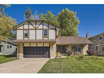 Charming Tudor-style home with well-maintained lawn and a two-car garage in a suburban neighborhood at 10365 E Weaver Cir, Englewood, CO 80111