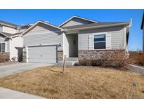 Charming single Gathering home with light gray siding and stacked stone detail on a sunny day at 2303 Angus St, Mead, CO 80542