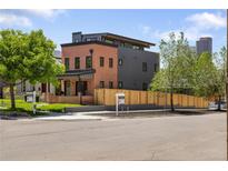 Modern home with brick and metal siding, featuring a well-manicured lawn and professional landscaping at 2395 N Emerson St, Denver, CO 80205