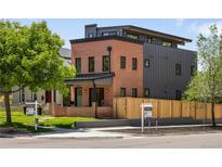 Charming two-story home featuring a brick facade, black accents, and a well-manicured lawn, exuding modern elegance at 2395 N Emerson St, Denver, CO 80205