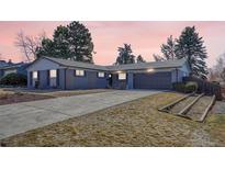 Charming single-story home with a gray brick exterior, well-maintained lawn, and a spacious driveway at 3802 E Costilla Ave, Centennial, CO 80122