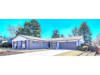 Charming single story home with a well-manicured lawn, mature trees, and a long driveway at 3802 E Costilla Ave, Centennial, CO 80122