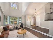 Bright living room featuring high ceilings, hardwood floors, and many windows with lovely views at 2980 E 135Th Dr, Thornton, CO 80241