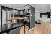 Charming kitchen featuring stainless steel appliances and sleek dark cabinets at 1390 N Emerson St # 101, Denver, CO 80218