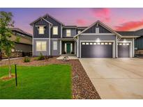 Charming two-story home featuring a three-car garage and a well-manicured front yard with lush green grass at 3256 Offbeaten Pl, Castle Rock, CO 80108