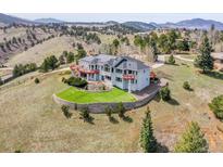 Majestic home with red accents features professional landscaping and a serene, mountainous backdrop at 260 Dekker Dr, Golden, CO 80401