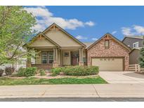 Charming single-Gathering home with a covered front porch, brick accents, and a well-manicured lawn at 6085 Nile Cir, Golden, CO 80403
