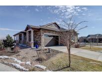 Charming stone-accented home with well-maintained landscaping and a two-car garage at 24963 E Phillips Pl, Aurora, CO 80016