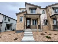 Charming townhome with stone accents, covered porch, and well-maintained gravel landscaping at 6668 N Nepal Ct, Aurora, CO 80019