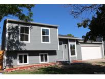 Charming gray two-story home with an attached garage and well-maintained front yard at 1705 Cathay Ct, Aurora, CO 80011