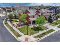 Well-manicured lawn surrounds this beautiful two-story home with wood fence and mature trees on a corner lot at 22965 Allendale Ave, Parker, CO 80138