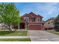 Charming two-story home with a well-manicured lawn and beautiful mature tree providing shade at 22965 Allendale Ave, Parker, CO 80138