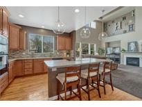 Bright kitchen featuring a large island with seating, modern appliances, and hardwood floors at 22965 Allendale Ave, Parker, CO 80138