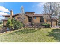 Beautiful two-story home with a tile roof, chimney, manicured lawn, and mature landscaping at 7850 Vallagio Ln, Englewood, CO 80112