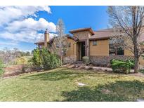 Attractive home featuring manicured lawns, stone accents, and professional landscaping for enhanced curb appeal at 7850 Vallagio Ln, Englewood, CO 80112