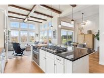Contemporary kitchen island with a gas stovetop, views of the living area, and access to the outdoors at 7850 Vallagio Ln, Englewood, CO 80112