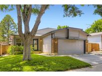 Charming one-story home with lush lawn, mature tree, and two car garage at 8432 S Upham Way, Littleton, CO 80128