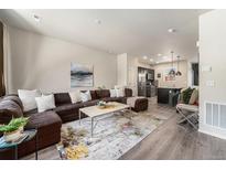 Inviting living room featuring a comfortable sectional sofa and an open layout leading into the kitchen at 1631 Aspen Meadows Cir, Denver, CO 80260