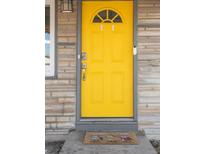 A bright yellow front door enhances the curb appeal of this charming home at 6000 Krameria St, Commerce City, CO 80022