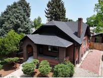 Charming brick home with a new roof, lush landscaping, and a cozy front porch, offers inviting curb appeal at 2636 N Glencoe St, Denver, CO 80207
