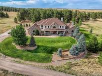 Stunning stone and stucco home with manicured lawn and mature trees for privacy at 36412 Paradise Cir, Elizabeth, CO 80107