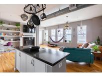 Bright living area featuring hardwood floors, modern fireplace, and a unique hanging hammock at 1489 Steele St # 104, Denver, CO 80206