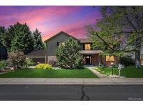 Charming two-story home with lush lawn, mature trees, and professional landscaping at sunset at 5755 S Fulton Way, Greenwood Village, CO 80111