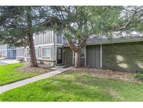 A charming exterior view of the home featuring a well-maintained lawn and mature trees at 13393 E Louisiana Ave, Aurora, CO 80012