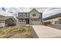 Inviting two-story home featuring a covered porch, neutral colors, and a well-maintained front yard at 935 Peach Leaf Ln, Elizabeth, CO 80107