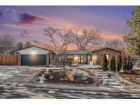 Charming brick home with professional landscaping, lush shrubbery and a two-car garage at 5121 W Plymouth Dr, Littleton, CO 80128