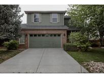 Two-story home boasts an attached garage, brick accents, a driveway, and mature landscaping at 11538 Hudson St, Thornton, CO 80233