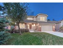 Lovely two-story home featuring a well-kept lawn, a two-car garage, and inviting curb appeal at 7454 Snow Lily Pl, Castle Pines, CO 80108