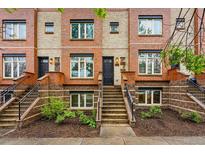 Brick townhome with steps leading to front door and manicured landscaping at 2319 Decatur St, Denver, CO 80211