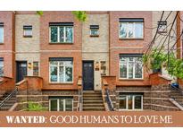 Charming brick townhome with a black door and well-manicured landscaping at 2319 Decatur St, Denver, CO 80211