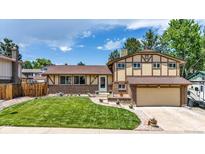 Charming home with a manicured lawn, brick accents, and a two-car garage at 6441 W 73Rd Pl, Arvada, CO 80003