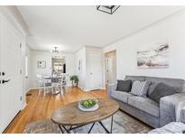 Bright living room with hardwood floors, modern decor, and seamless flow into the dining area at 3258 Niagara St, Denver, CO 80207