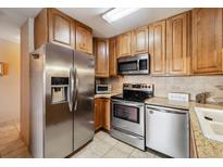 Well-equipped kitchen featuring stainless steel appliances, tile floors, and ample cabinet space at 715 S Alton Way # 5D, Denver, CO 80247
