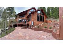 Stunning multi-level home with a stone driveway and spacious decks, perfect for enjoying the outdoors at 4618 Se Summit Trl, Evergreen, CO 80439