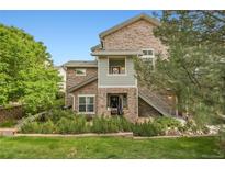 Charming townhome featuring a stone facade, private entrances, and lush green landscaping at 18761 E Water Dr # F, Aurora, CO 80013