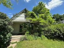 Charming home with decorative shingles and lush foliage surrounding the entrance at 1824 S Logan St, Denver, CO 80210