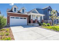 Charming brick-and-siding home with a two-car garage and covered front porch, landscaped for great curb appeal at 9843 Rosalee Peak St, Littleton, CO 80125