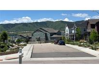 Scenic street view of suburban homes with mountain backdrop, manicured landscaping, and neighborhood charm at 9843 Rosalee Peak St, Littleton, CO 80125