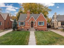 Brick home with landscaped lawn and walkway at 1545 Newport St, Denver, CO 80220