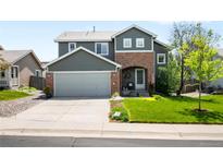 Charming two-story home with a well-manicured lawn, a gray exterior, and brick accent at 19716 Glendale Ln, Parker, CO 80134