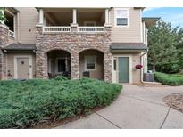 Charming condo with stone accents, covered porch, and well-maintained landscaping at 8338 S Independence Cir # 108, Littleton, CO 80128