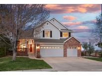 Charming two-story home featuring a well-maintained lawn and a three-car garage at sunset at 13804 Quail Ridge Dr, Broomfield, CO 80020